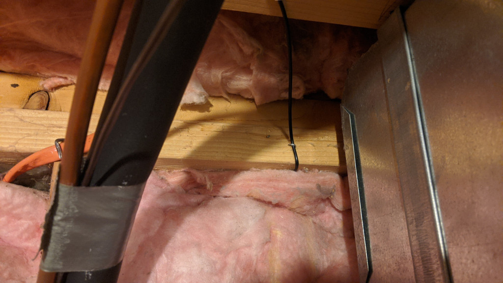 The fiber enters the house behind the fiberglass insulation then is routed up to studs or joists and secured with staples.