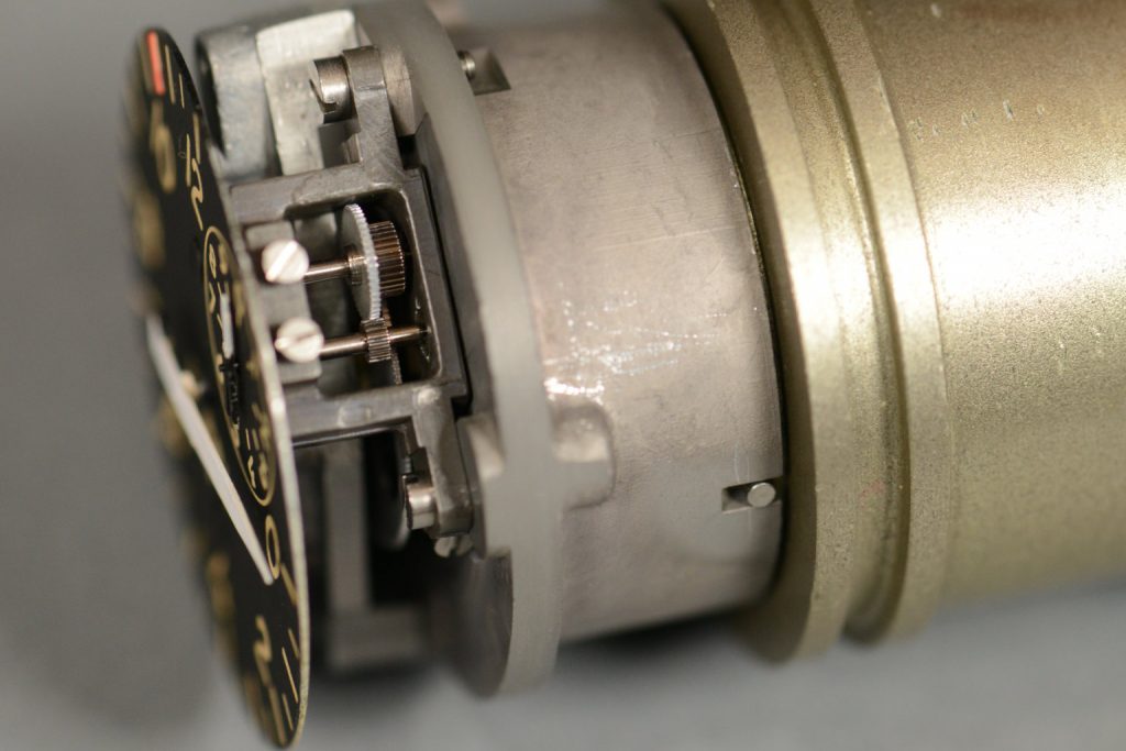 The large gear attached to the main dial's needle turns a bunch of smaller gears connected to the small dial's needle. This causes the small needle to spin very fast when the main needle changes quickly.