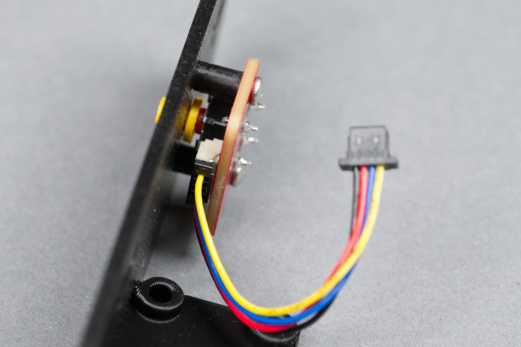 The button and plunger on the rear panel of the enclosure.