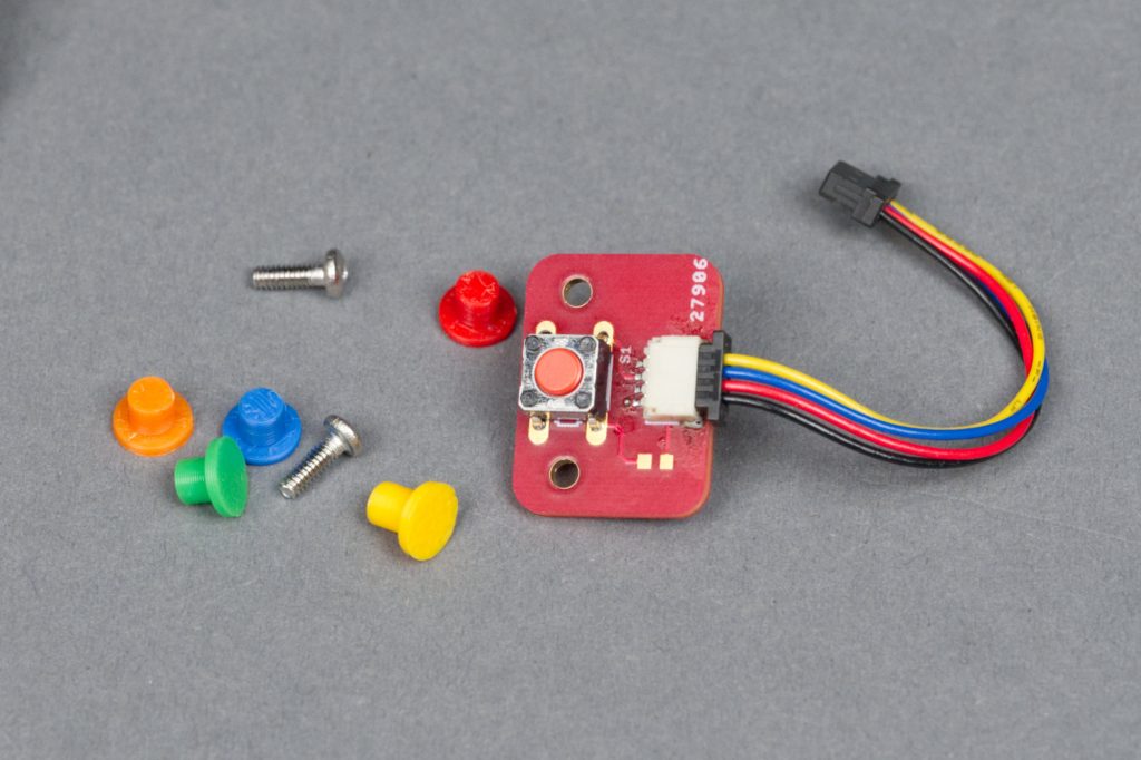 The assembled button board and several 3D-printed colored plungers.